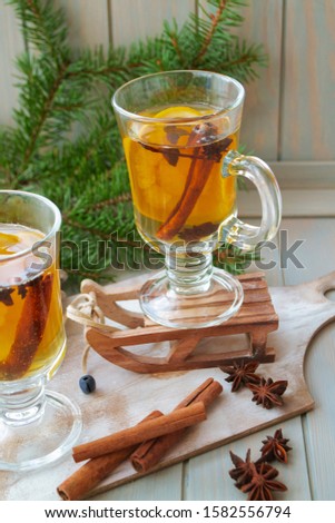 Hot mulled wine with Christmas spices and orange slices, anise and cinnamon sticks, vertical bright image