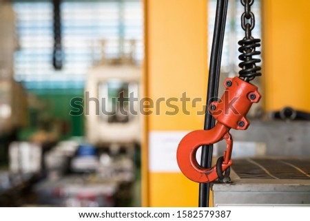 Crane hook of overhead crane in workshop to lift product stock in warehouse. Background inside of the industrial factory