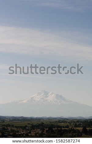 A beautiful vertical shot of a white mountain near town under a clear sky