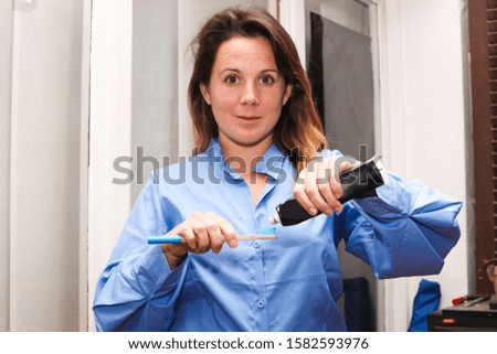 Woman brushing her teeth with activated carbon toothpaste.