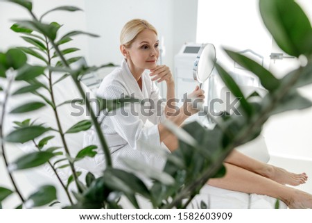 Attractive female admiring the reflection in the mirror stock photo
