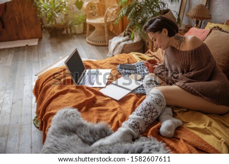 Pretty lady resting on bed with hot drink stock photo