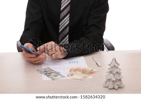 A businessman signs a contract and issues cash dollars and euros in an envelope.