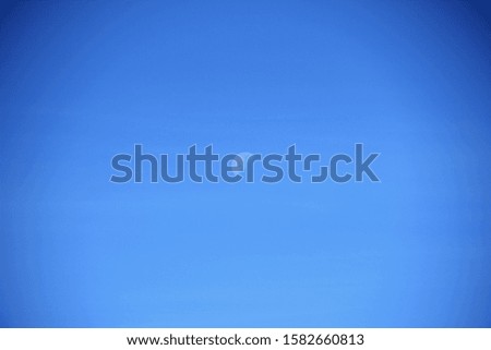 view of the moon during a summer day against a clear blue sky