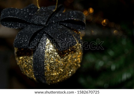 Dark shiny Christmas decor. Luxury Christmas background with a sparkling ball close-up.