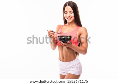 Smiling girl with bowl of salad and a fork. Concept of healthy low calorie meal after training. Mock up.