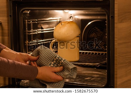 Easter cake in an iron mug put in the oven for baking Royalty-Free Stock Photo #1582675570