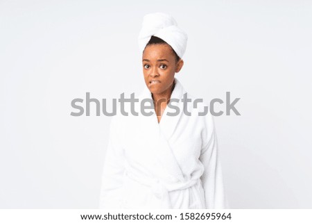 African american woman  in a bathrobe over isolated background having doubts and with confuse face expression