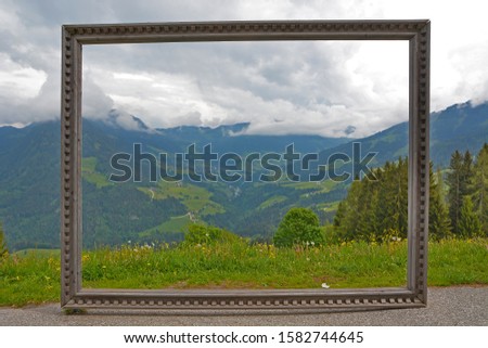 Beautiful landscape view of the Austrian Alps, seen through an antique wood picture frame
