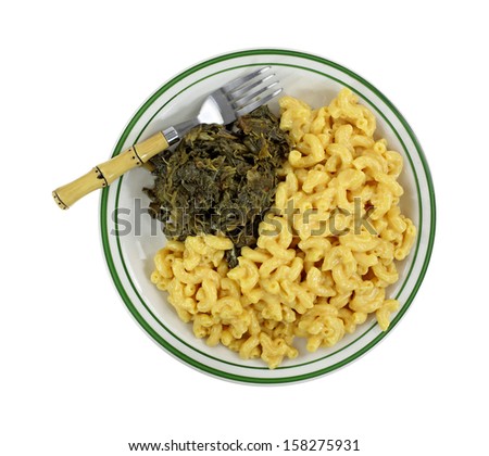 Cooked macaroni and cheese, turnip greens on a green striped plate with fork on a white background