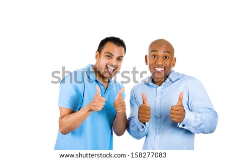 Closeup portrait of two young friendly men, happy coworkers; smiling young business partners, students giving thumbs up sign, isolated on white background with copy space. Corporate life, deal making