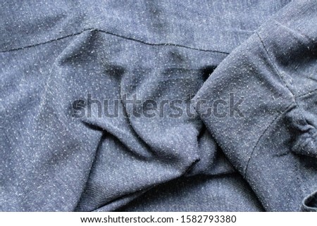 Pills on the heather blue tee-shirt cotton knit fabric. Bobbles on the knitwear. Royalty-Free Stock Photo #1582793380
