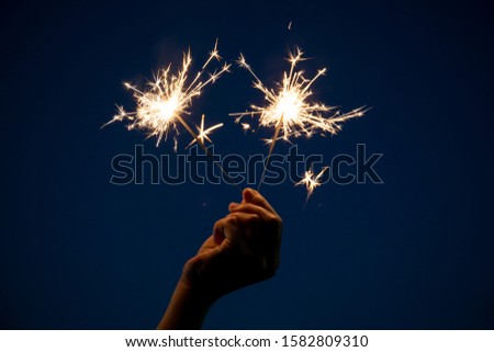 Girl enjoy playing with a small sparkler hand fireworks, celebrating in Christmas and New Year festival.