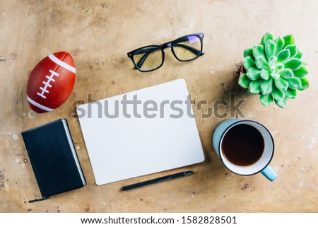 Flat lay Man set: cup of coffee, black notebook, ball and glasses on rustic beige background. Top view.