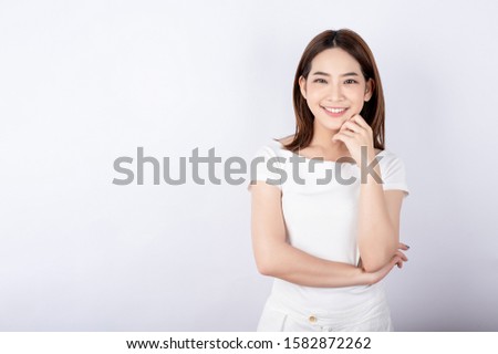 Beautiful young asian stand and pose with big smile happy beaming face in white background. Royalty-Free Stock Photo #1582872262
