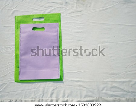 Beautiful Colored Bags, Eco Bags lying on White Background, Non Woven Bags for Shopping, Environment Friendly Concept