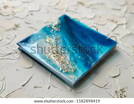 handmade book with a cover in the resin art technique on a textural background. imitation of the sea. Epoxy resin