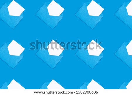 Top view of trendy pattern made with white blank card in blue opened craft envelope on background. Minimal concept. Trendy color background.