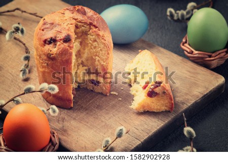 Easter cake on a cutting board and colored eggs - traditional easter breakfast