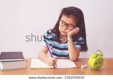Bored and tired asian student girl doing homework 