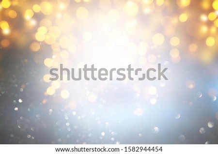 abstract background of glitter vintage lights . silver, gold and blue. de-focused