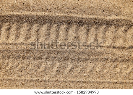 Tyre prints on the yellow sand. Nature background or texture in a day