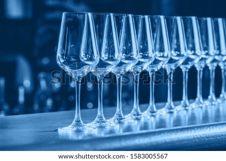 Wine glasses in a row. Buffet table celebration of wine tasting. Nightlife, celebration and entertainment concept. Horizontal, cold toned image