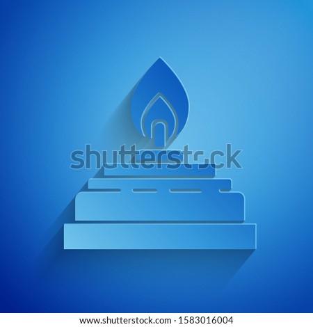 Paper cut Alcohol or spirit burner icon isolated on blue background. Chemical equipment. Paper art style. Vector Illustration
