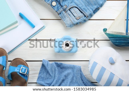 Flat lay composition with little photographer's toy camera on white wooden background