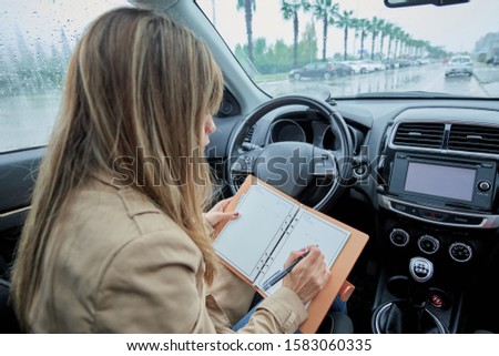business woman in the car writing in her agenda