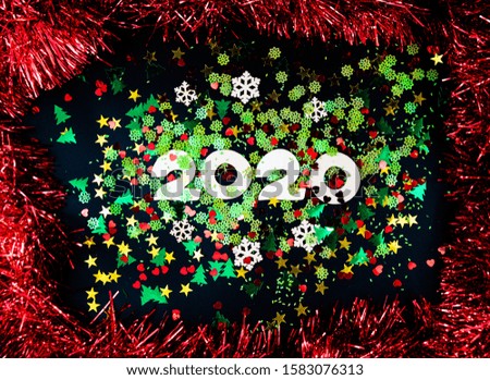 Christmas, New Year composition. White number 2020, red tinsel frame, colorful confetti on black background. Flat lay, top view festive holiday mockup