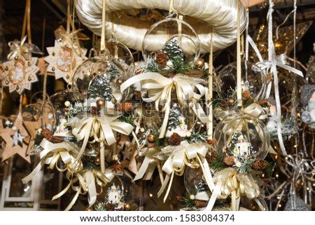 Christmas white decorations and ornaments on the market in Vienna. For sale on Christmas fair in Vienna. Colored xmas globes, balls, bulbs and feathers details, fairy-tale scene