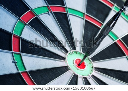 dart hitting on dartboard, Success hitting target aim goal achievement concept background – three dart in bull’s eye close up.