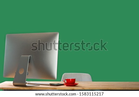 Workspace with computer, keyboard,coffee cup and Mouse with Blank or White Screen Isolated is on the work table at the mountain and Sea green background.