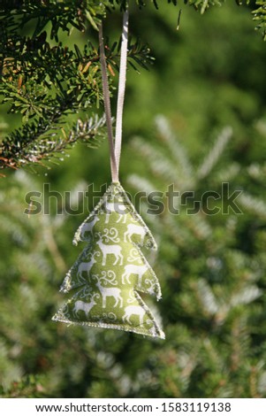 Hand made Christmas decoration from felt hanging on Christmas tree