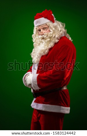 Male actor in a costume of Santa Claus dancing, gesturing and posing