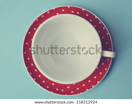 Red cup of polka dots on blue background vintage