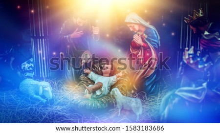 The statue of Mary Joseph and Jesus, Jesus' birthday baby is a statue of Maria and Joseph and Jesus, a newborn baby. There is a beautiful aura light on the hay. Christmas nativity scene