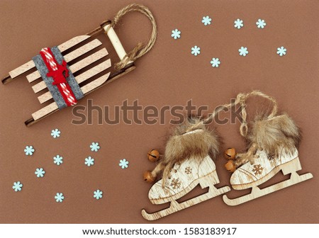 christmas flat lay with natural decoration snowflakes sleigh ice skates on brown backgound 