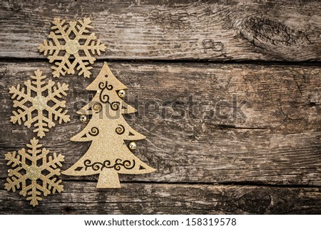 Gold Christmas tree decorations on grunge wood background. Winter holidays concept. Copy space for your text
