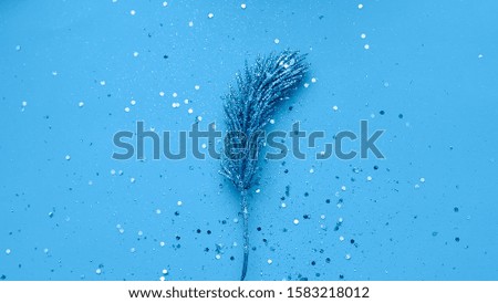 Branch of christmas tree on blue background with glitters.