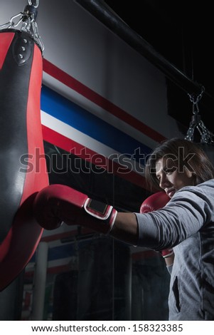 Determined boxer training at the gym on the punch bag