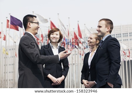 Four smiling multi-ethnic business people talking outdoors in Beijing