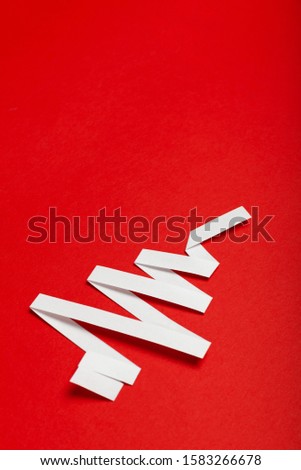 Christmas tree made of paper on a red background. Merry Christmas advertising for covers, invitations, posters, banners, flyers, placards.