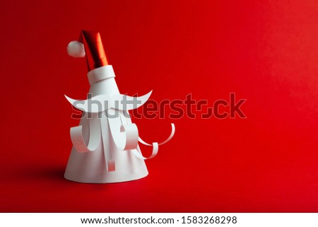 Homemade paper figure of Santa Claus on red background. Christmas art, banner for celebrate.
