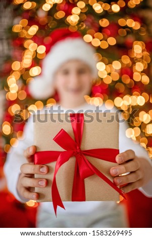 happy boy holds box with gift for advent holiday.  Merry Christmas and Happy New Year