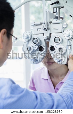 Optometrist doing eye exam on young woman