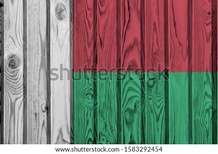 Madagascar flag depicted in bright paint colors on old wooden wall. Textured banner on rough background