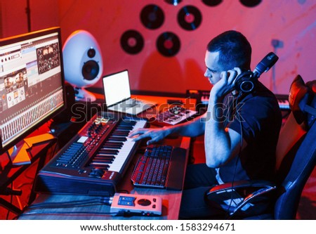 Young soung engineer working and mixing music indoors in the studio.