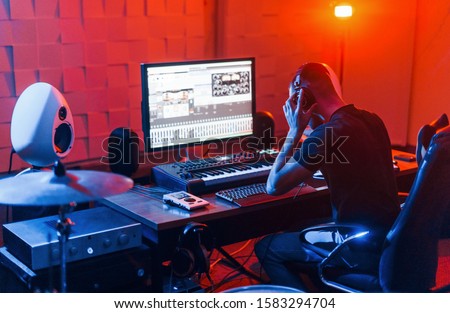 Guy have a job with project and mixing music indoors in the studio.